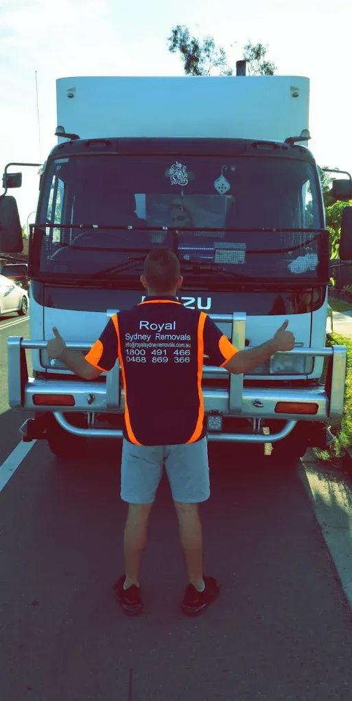 Royal Sydney Removals crew member in a branded hi-vis vest in front of one of the company Isuzu trucks