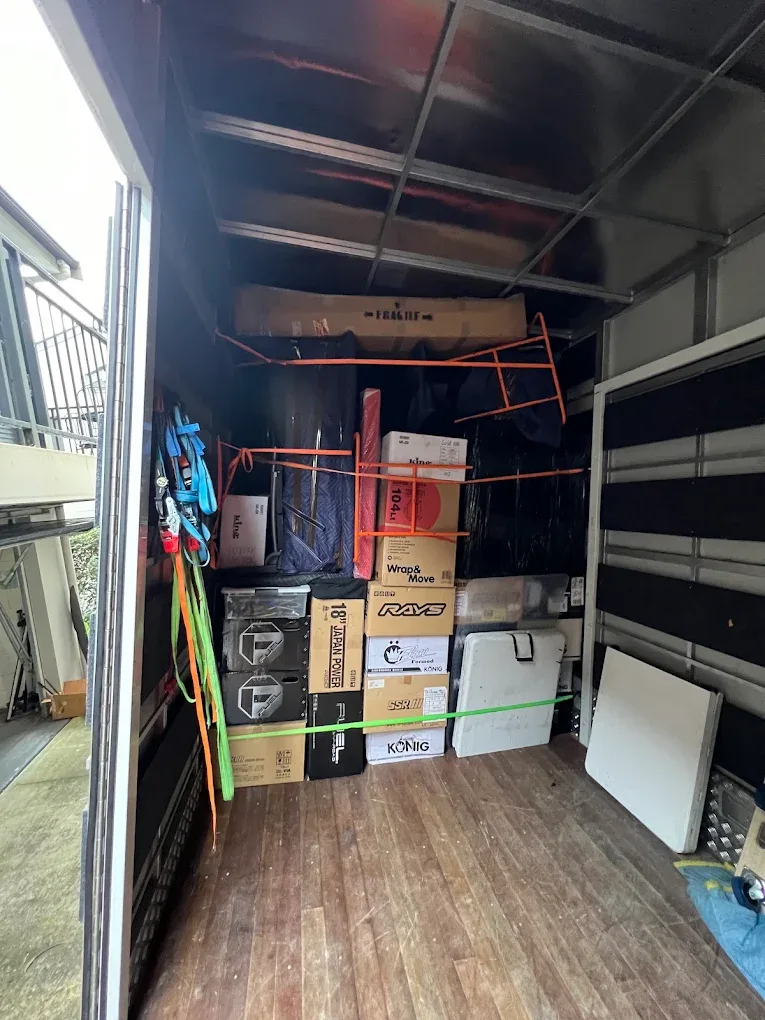 Inside a loaded Royal Sydney Removals truck, boxes and furniture strapped and blanket-wrapped for transit
